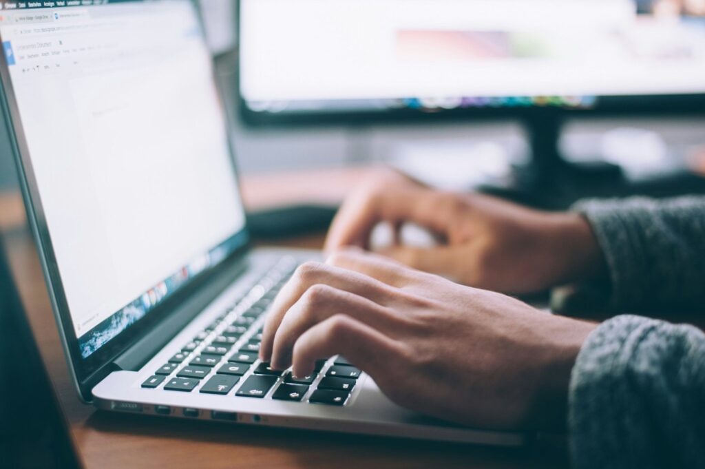 A person is working on building a website on a laptop