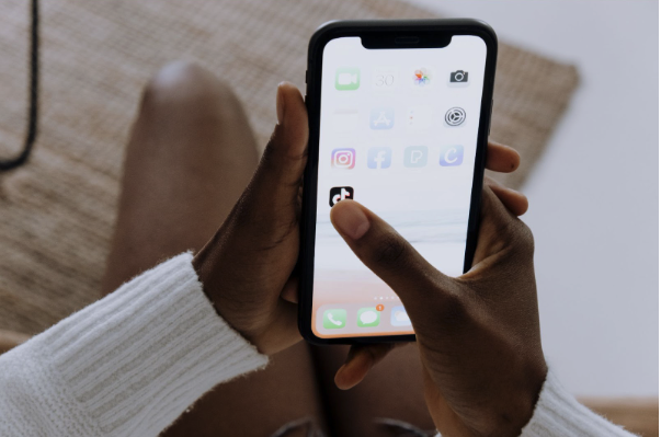 Une personne ouvre l'application TikTok sur un smartphone