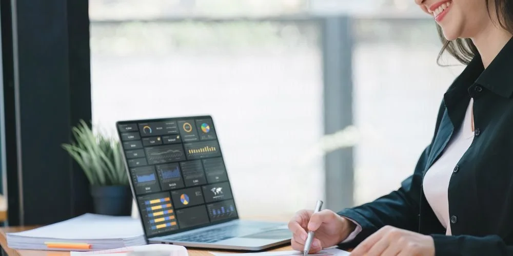 Une femme analyse un tableau de bord marketing sur un ordinateur portable