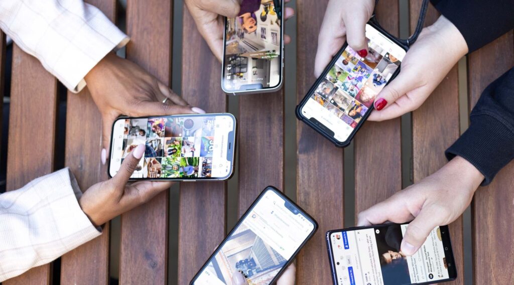 Mehrere Personen nutzen verschiedene Social-Media-Apps auf Smartphones