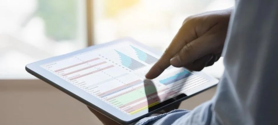 A person analyzes charts on a tablet