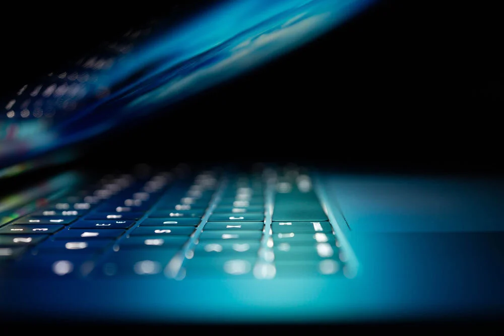 Close-up of an illuminated laptop keyboard as a symbol of online security