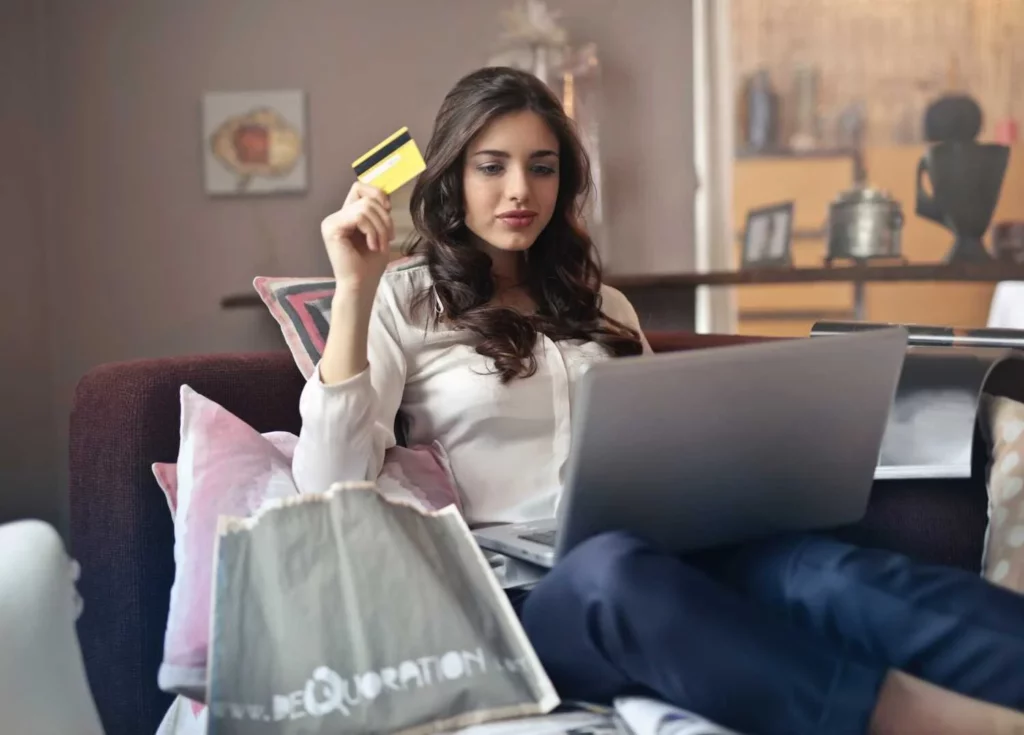 A woman uses her credit card to buy a laptop