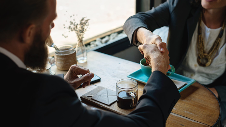 Two people shake hands during a conversation