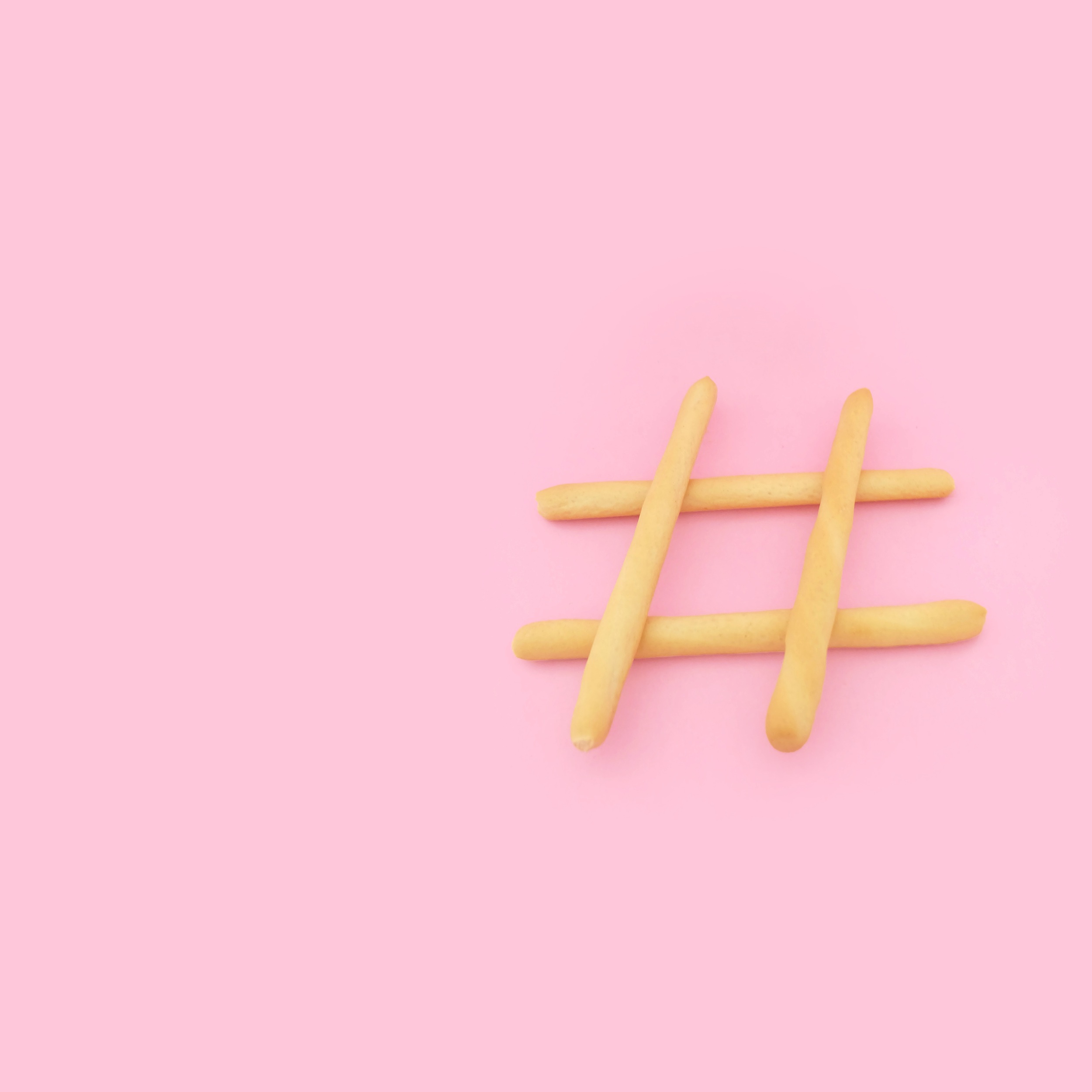 A hashtag symbol made up of four lines on a pink background