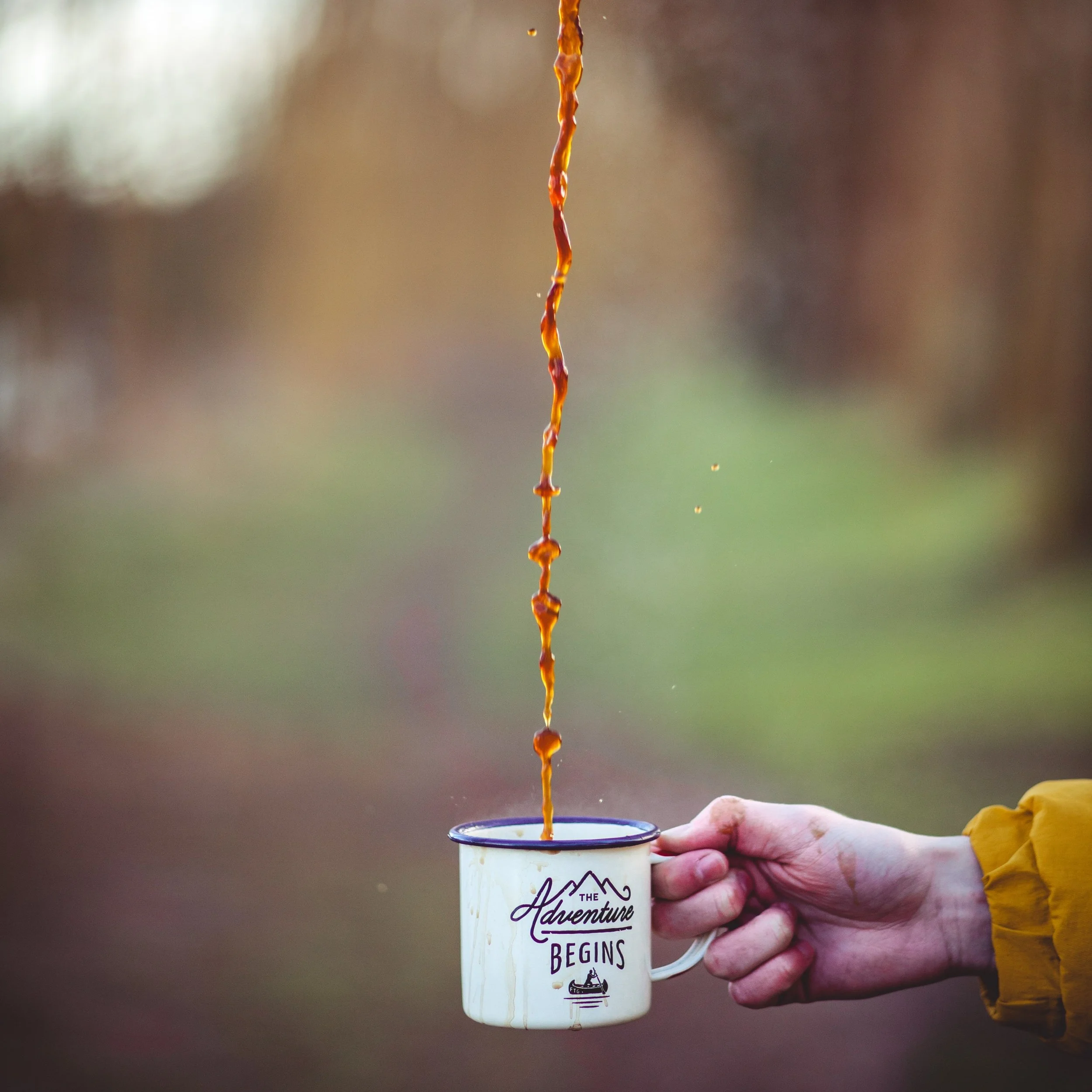 Coffee is poured into a cup from a great height