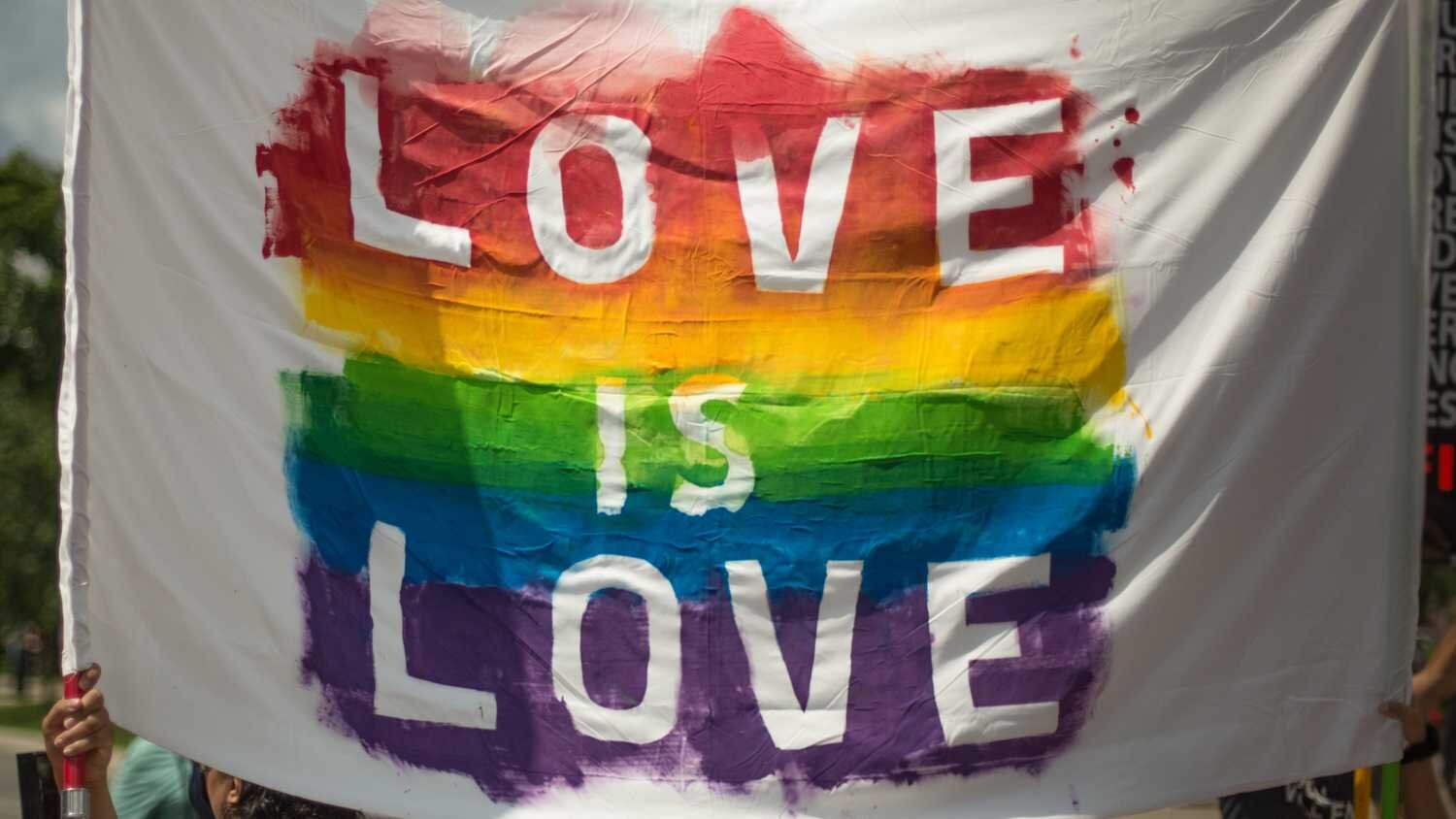 Bannière portant l'inscription « Love is Love » aux couleurs de l'arc-en-ciel.