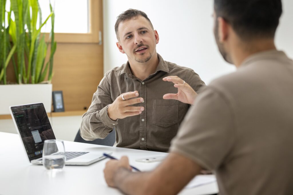 Two onlineKarma employees discuss a digital project at a table