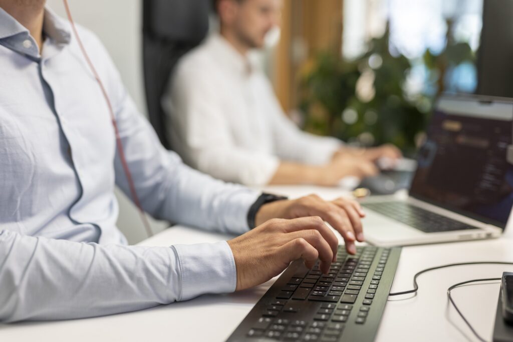 Detailaufnahme eines Mitarbeiters bei der Arbeit am Computer