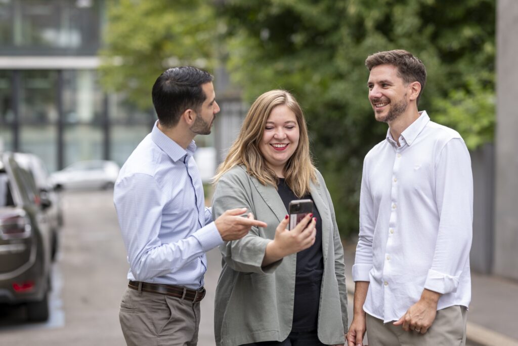 Three members of the onlineKarma executive team chatting outdoors