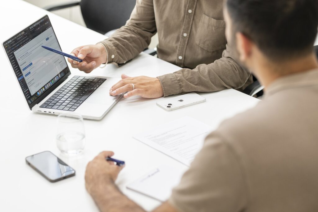 An onlineKarma employee explains technical content on a laptop