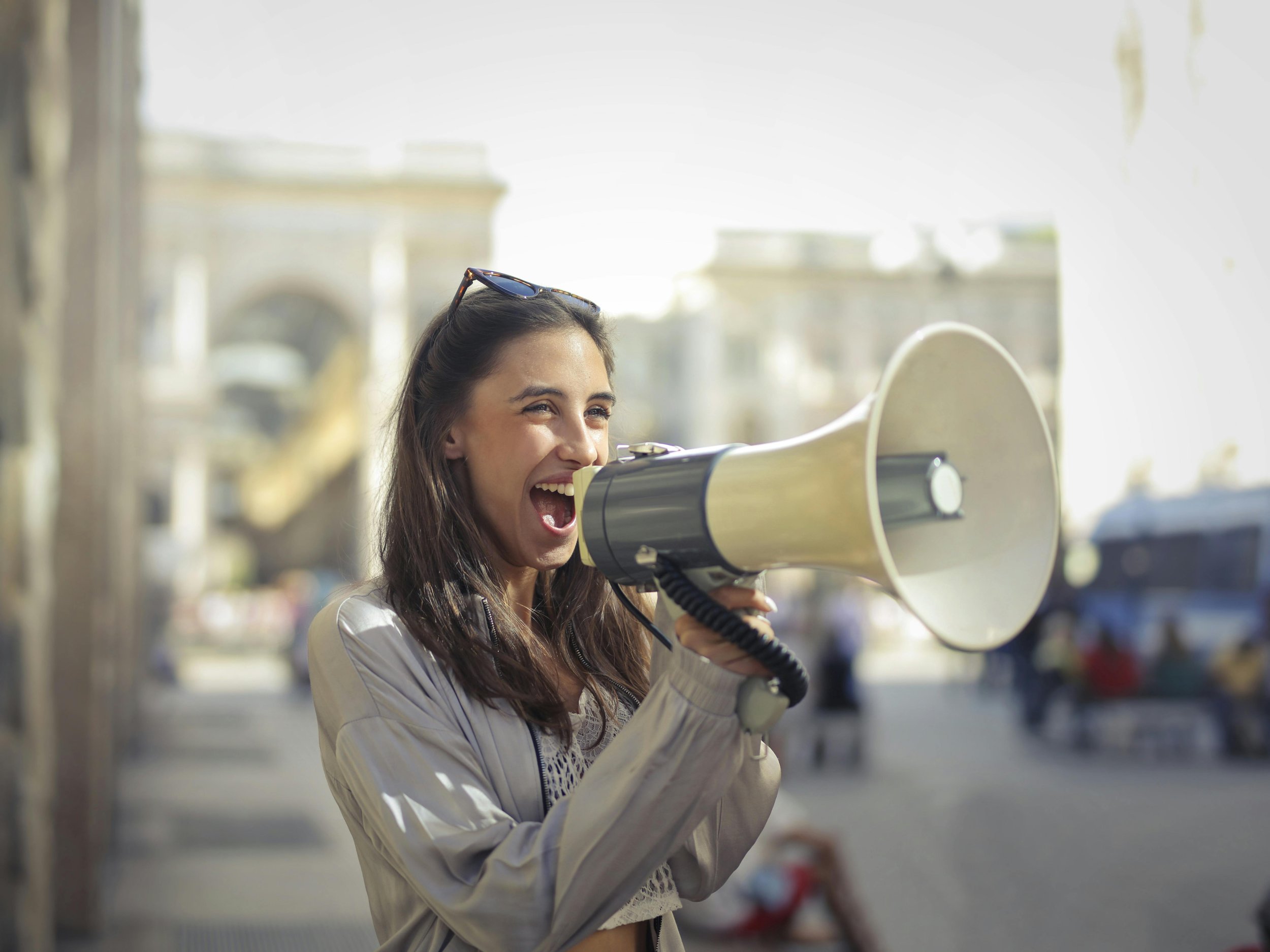 A woman speaking through a megaphone as a symbol of sharing content